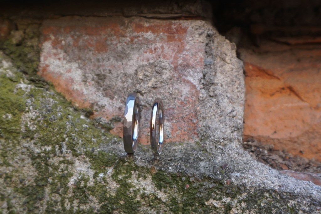 Handgefertigte Weißgoldringe 585 – ein poliertes Rundprofil und ein mattierter Facettenring, individuelle Trauringe aus meinem Atelier auf der Feinkost Leipzig, fotografiert auf dem Feinkosthof.