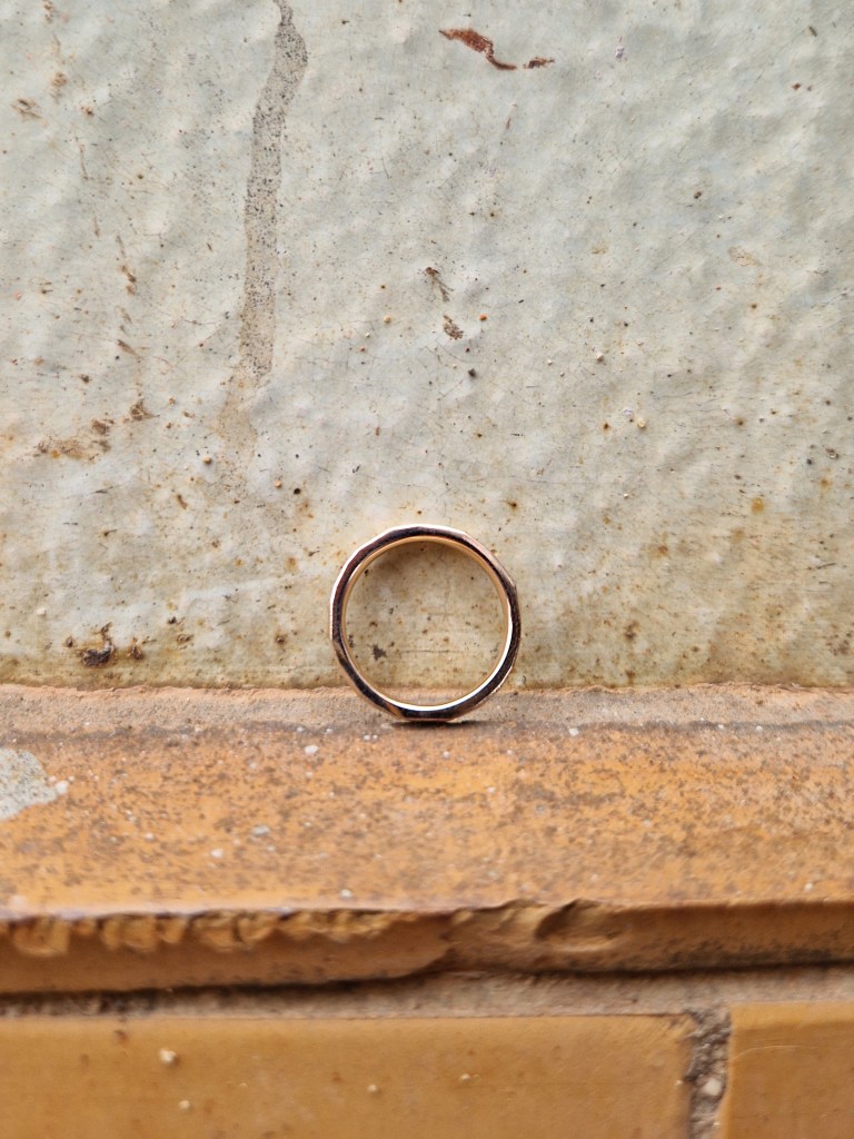 Facettenring Roségold 585/
an Fliesenwand, seitliche Ansicht